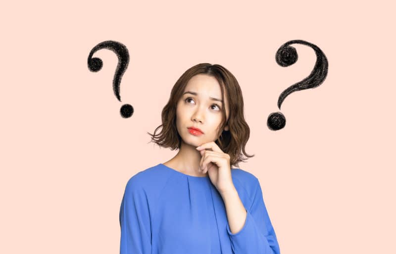 Asian woman thinking with questions marks drawn around her