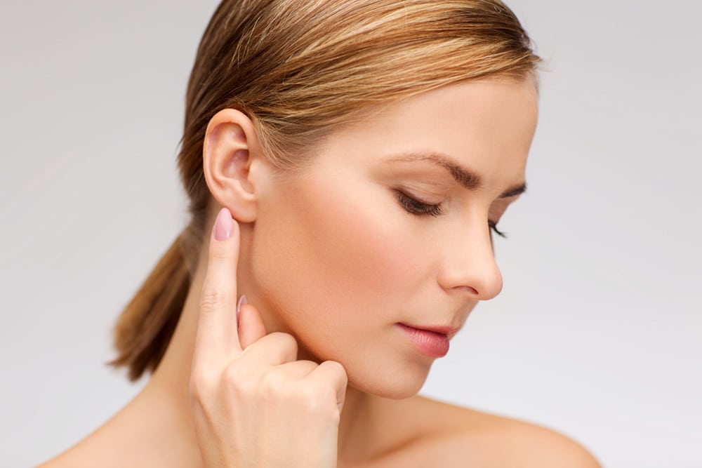 Profile of woman pointing to under-eye area during Pasadena wrinkle reduction consultation at Dynasty Dermatology Pasadena, CA