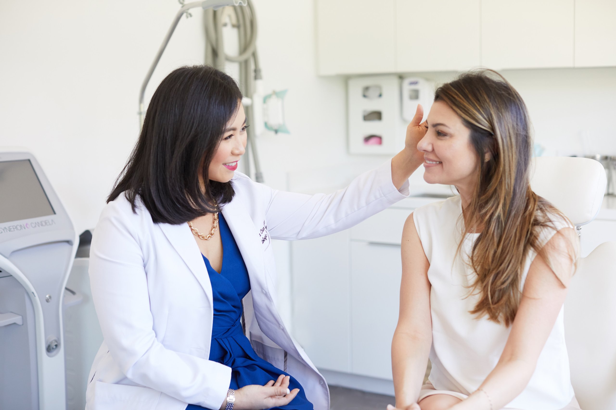 Dr. Joanna Chan, MD, examining a female patient. Both women are smiling