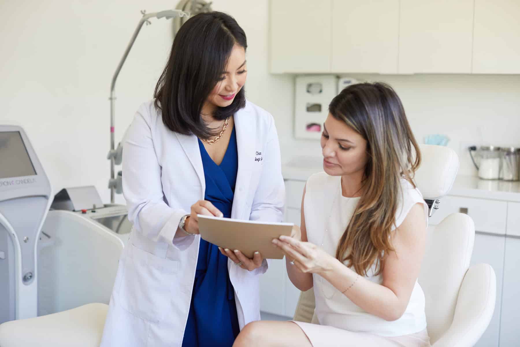 Dr. Joanna Chan, MD, showing paperwork to a female patient
